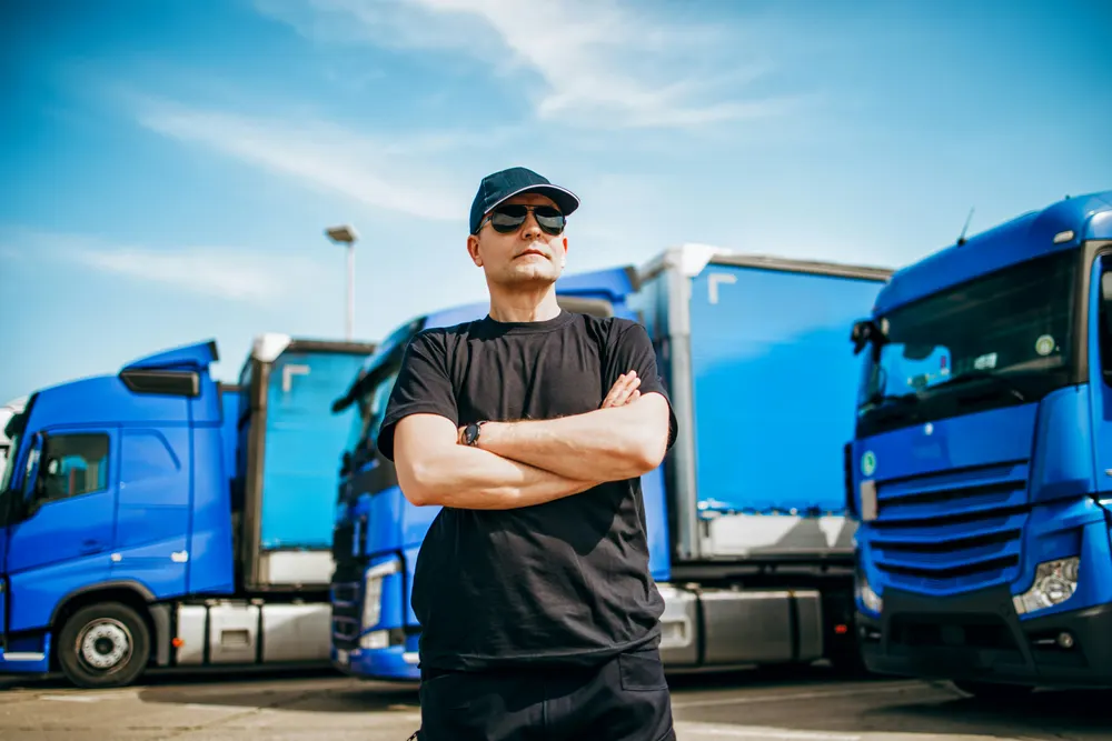 Kraftfahrer vor der Lkw-Flotte