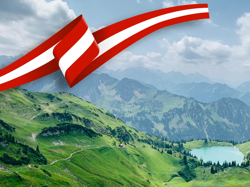 Rot-weiß-rote Schleife über einem Alpental